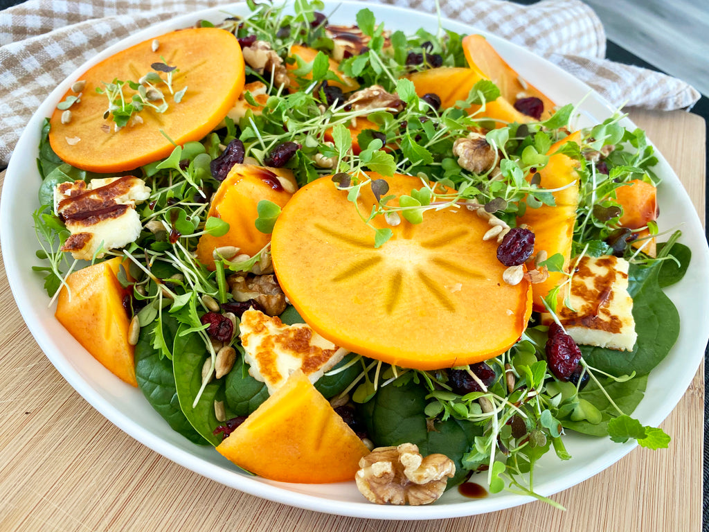 Healthy autumn persimmon salad with microgreens
